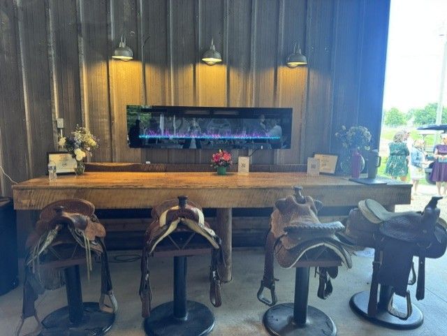 Rustic bar with leather saddle bar stools and a built-in fireplace display