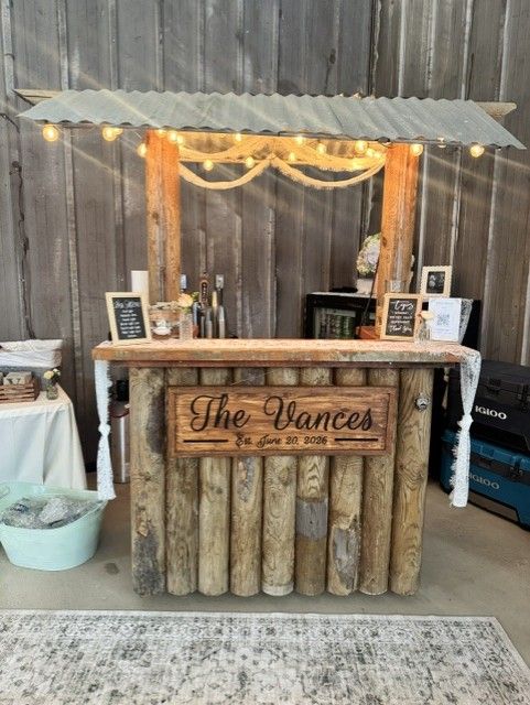 Rustic log bar built from wood posts with string lights overhead
